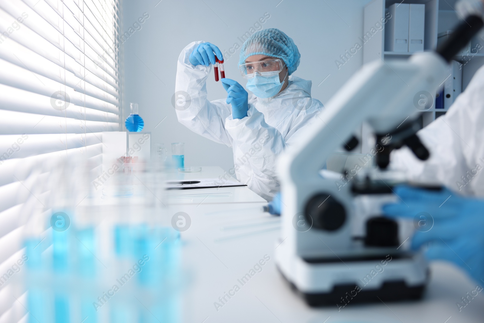 Medical analysis. Scientist working with blood samples in laboratory, selective focus Photo of Medical analysis. Scientist working with blood samples in laboratory, selective focus