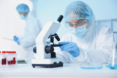 Photo of Medical analysis. Scientist working with microscope in laboratory, selective focus