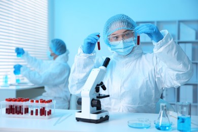 Photo of Medical analysis. Scientist working with blood samples in laboratory, selective focus