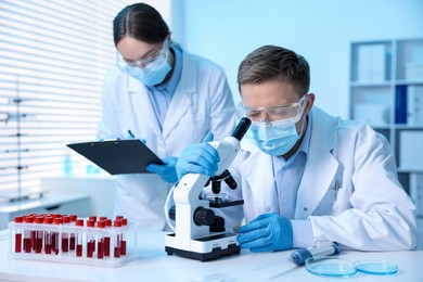Photo of Medical analysis. Scientists working with microscope in laboratory