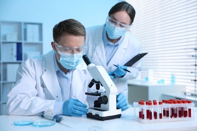 Photo of Medical analysis. Scientists working with microscope in laboratory