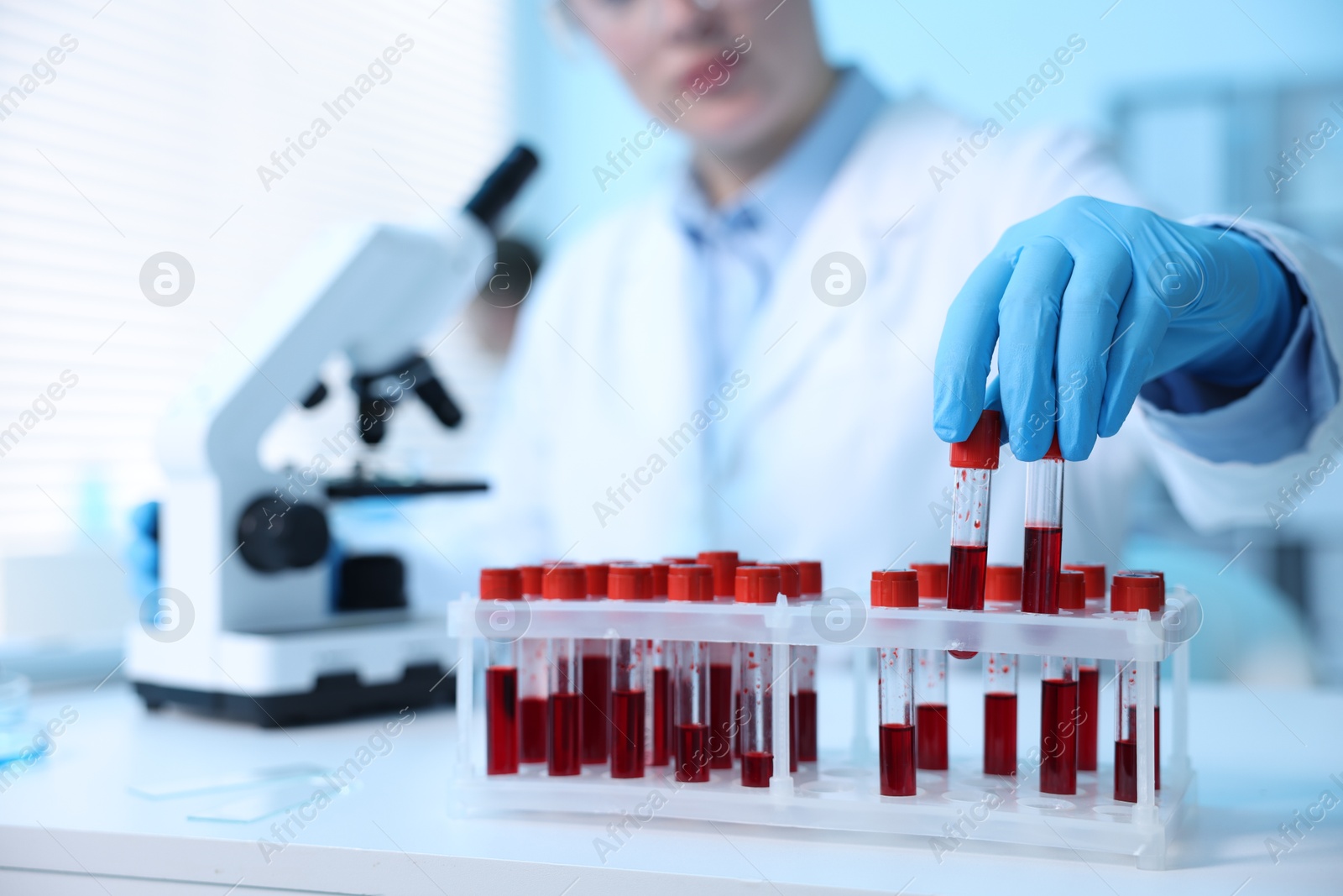 Medical analysis. Scientist working with blood samples in laboratory, selective focus Photo of Medical analysis. Scientist working with blood samples in laboratory, selective focus