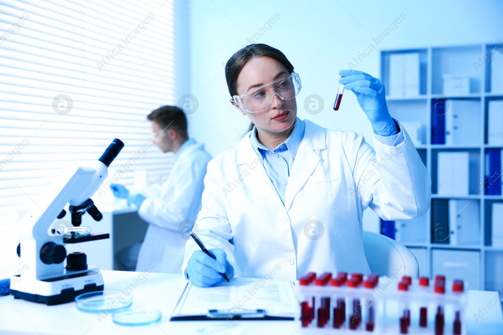Medical analysis. Scientist working with blood sample in laboratory, selective focus Photo of Medical analysis. Scientist working with blood sample in laboratory, selective focus