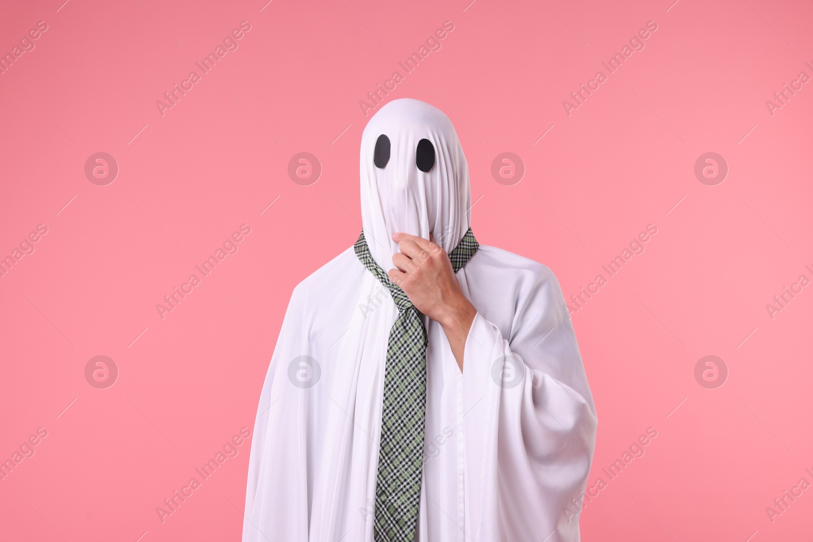 Photo of Man in ghost costume with tie on pink background