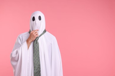 Photo of Man in ghost costume with tie on pink background. Space for text