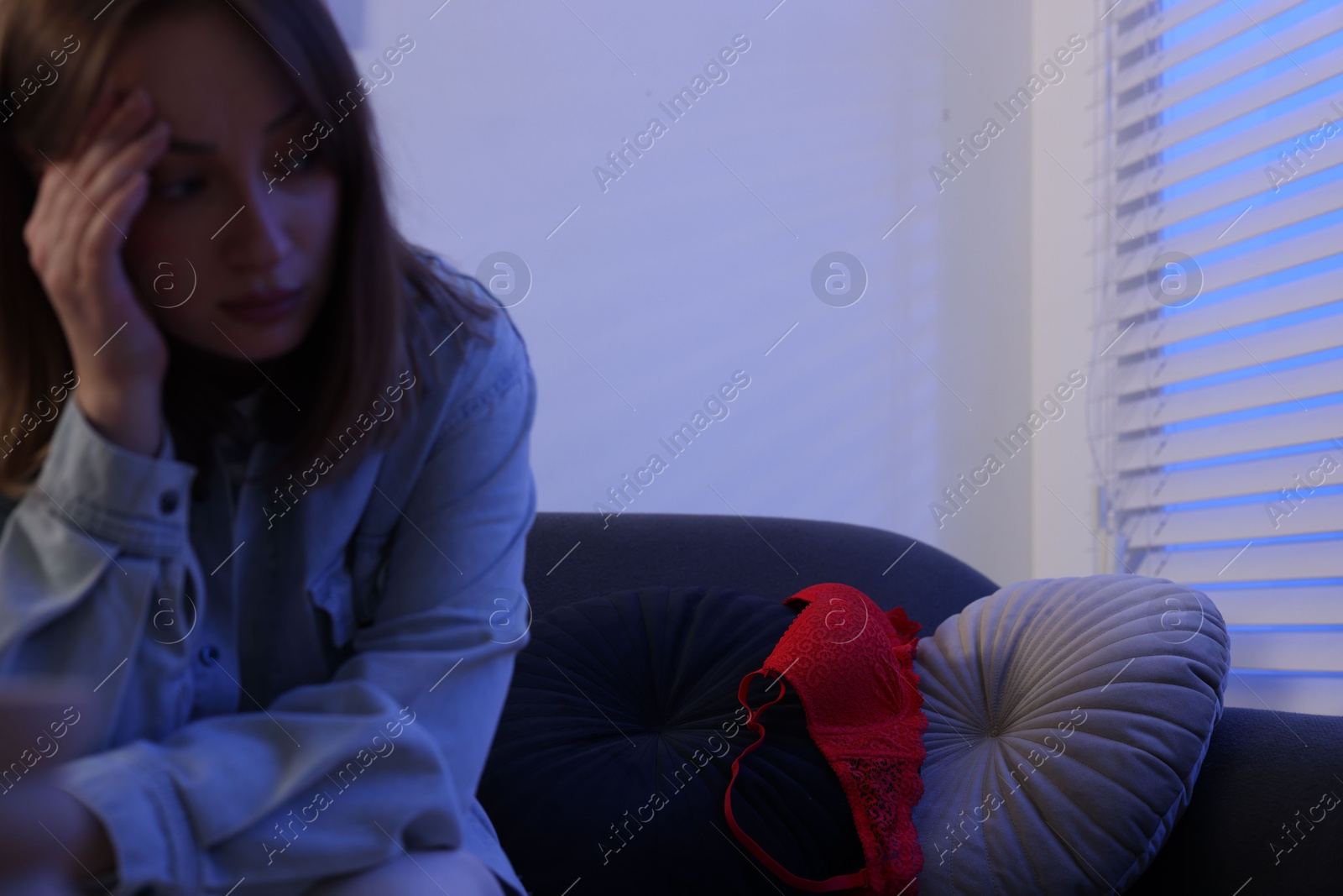 Photo of Betrayal. Frustrated wife and mistress bra on sofa at home, selective focus