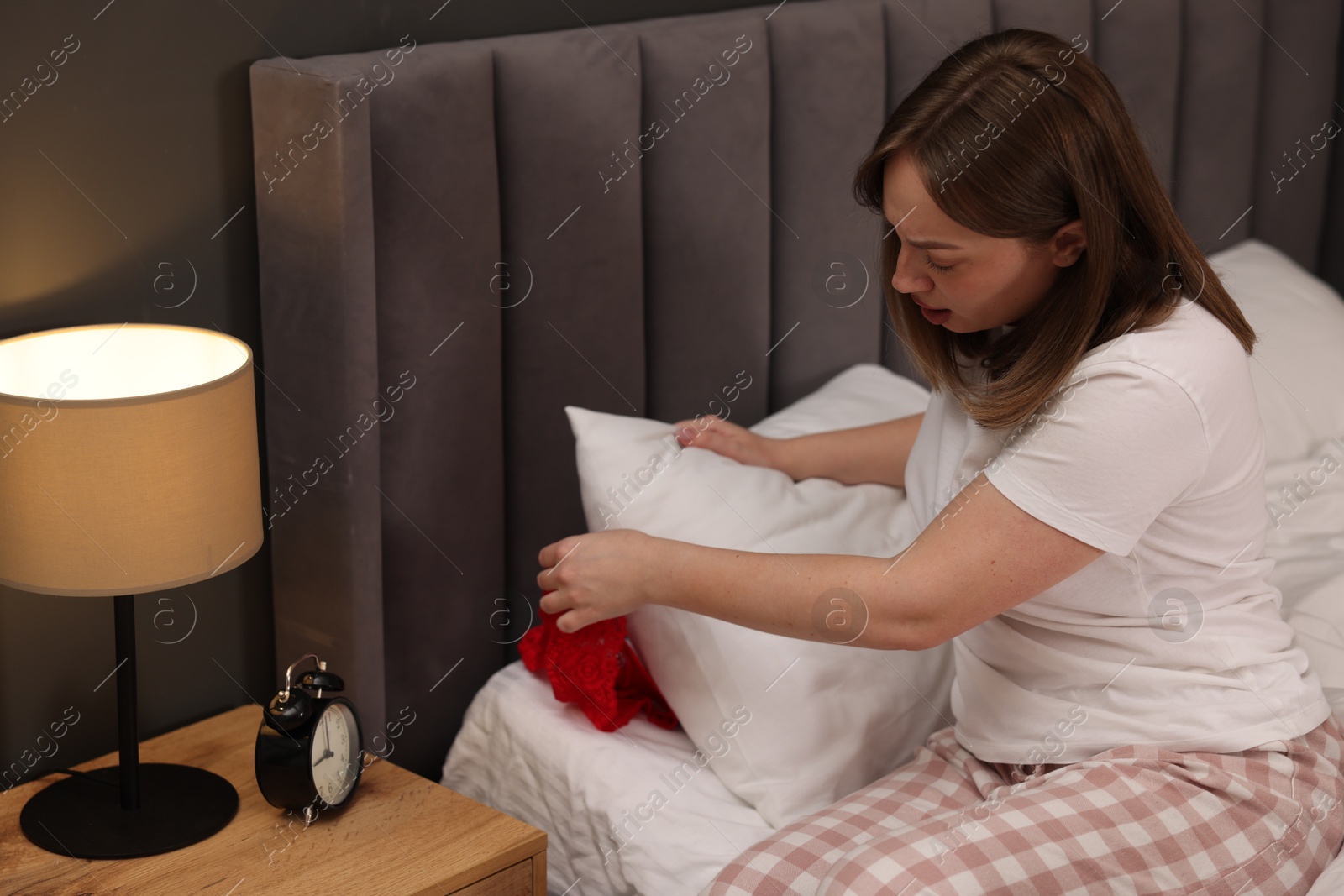 Photo of Betrayal. Shocked wife finding mistress panties on bed at home