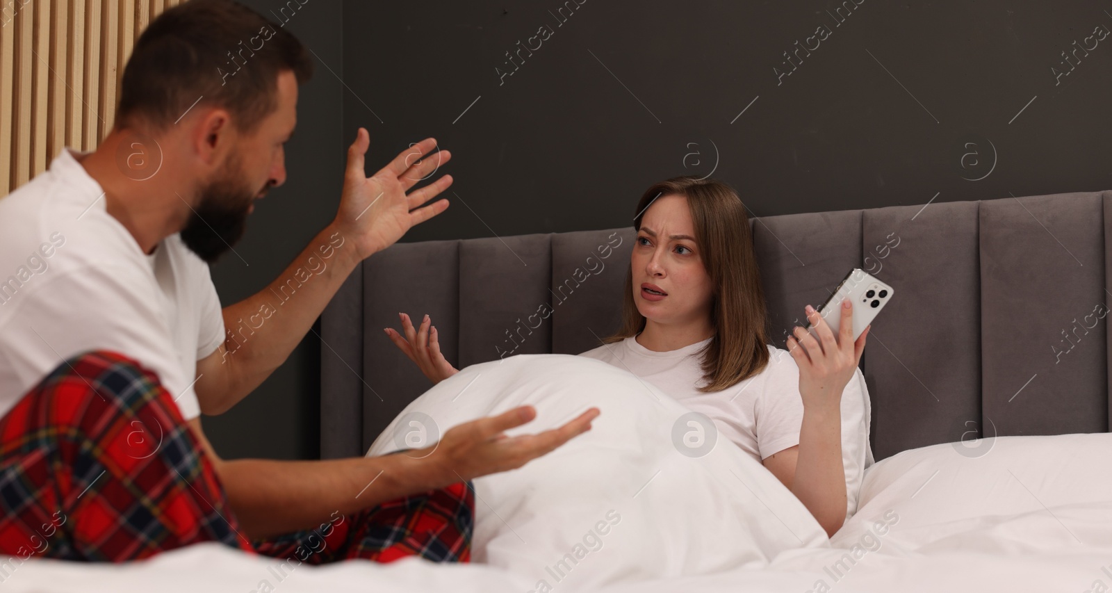 Betrayal. Couple arguing on bed at home Photo of Betrayal. Couple arguing on bed at home