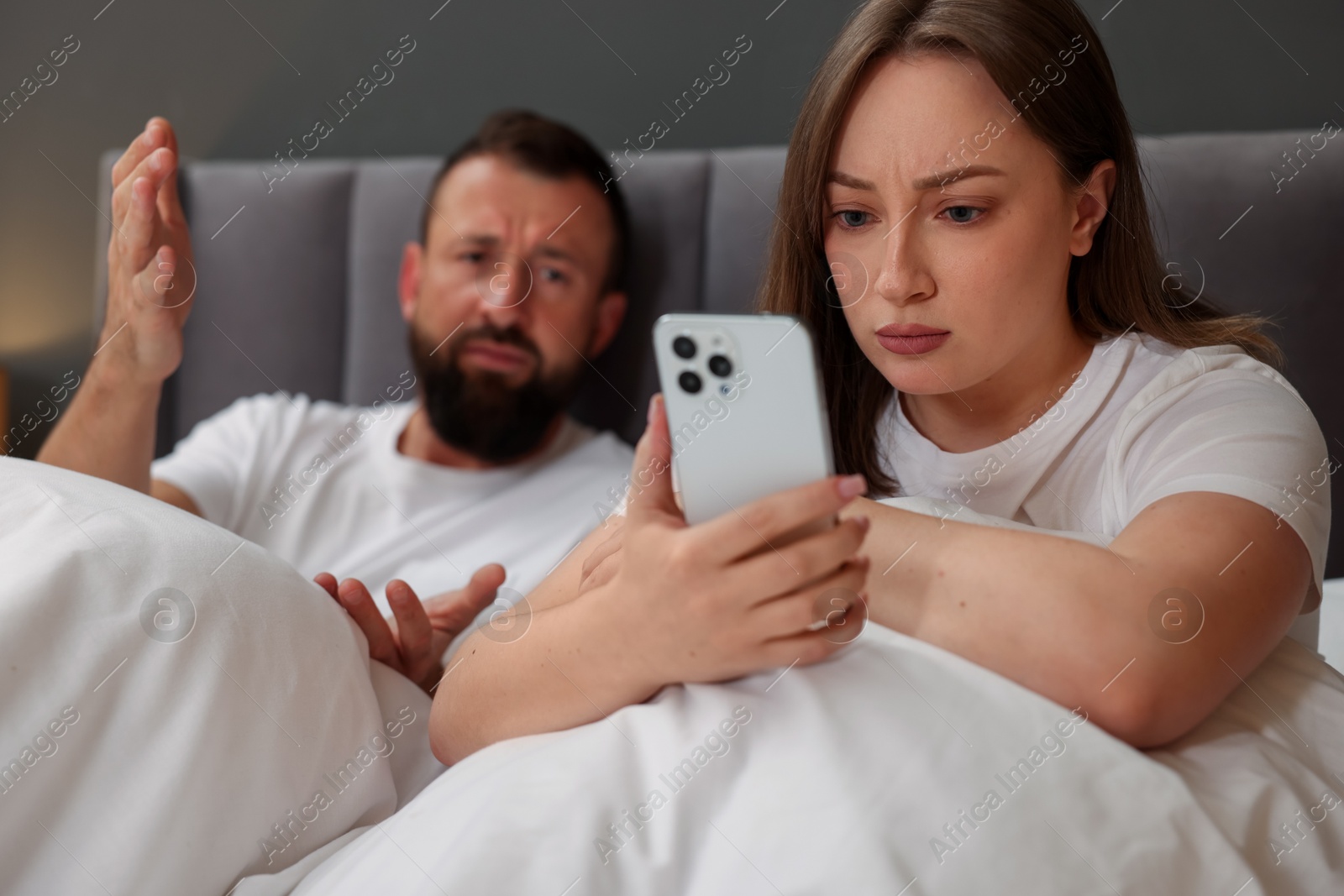 Betrayal. Couple arguing in bed at home Photo of Betrayal. Couple arguing in bed at home