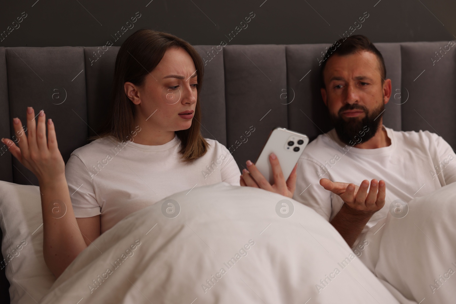 Betrayal. Couple arguing in bed at home Photo of Betrayal. Couple arguing in bed at home