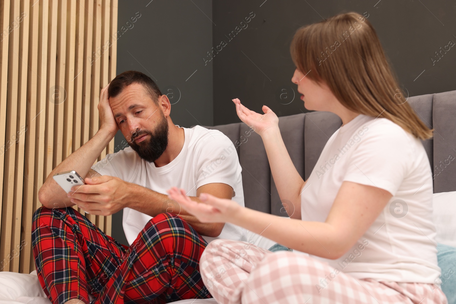 Betrayal. Couple arguing on bed at home Photo of Betrayal. Couple arguing on bed at home
