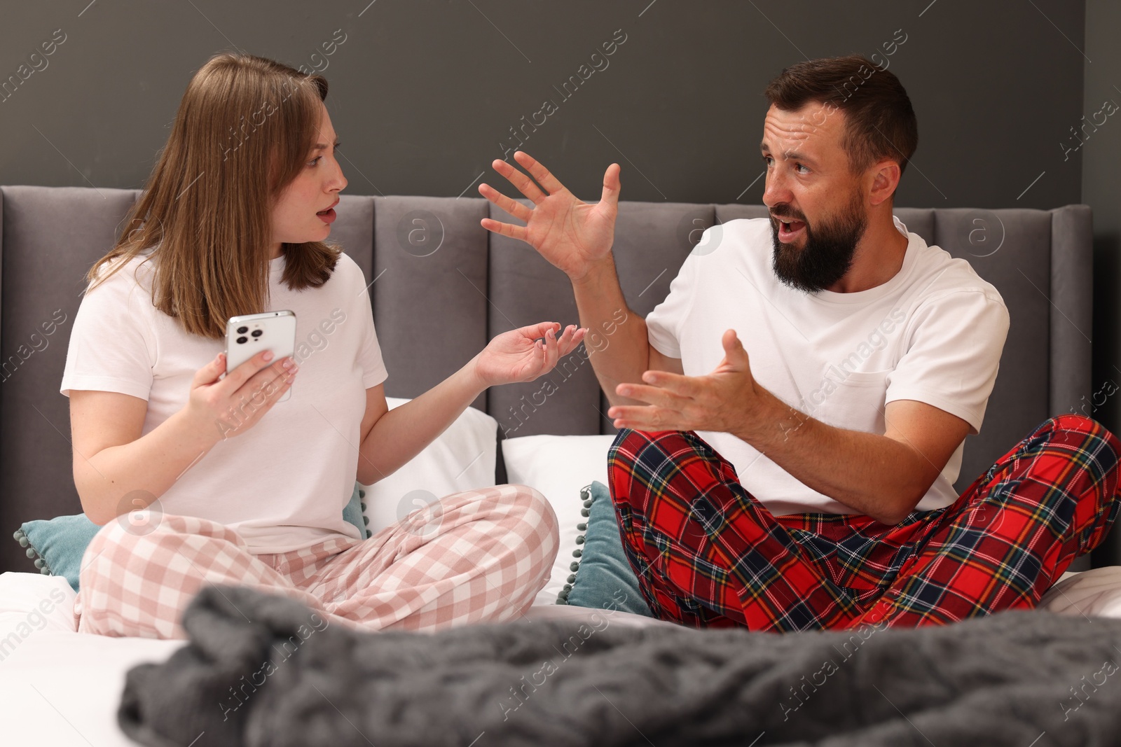 Betrayal. Couple arguing on bed at home Photo of Betrayal. Couple arguing on bed at home