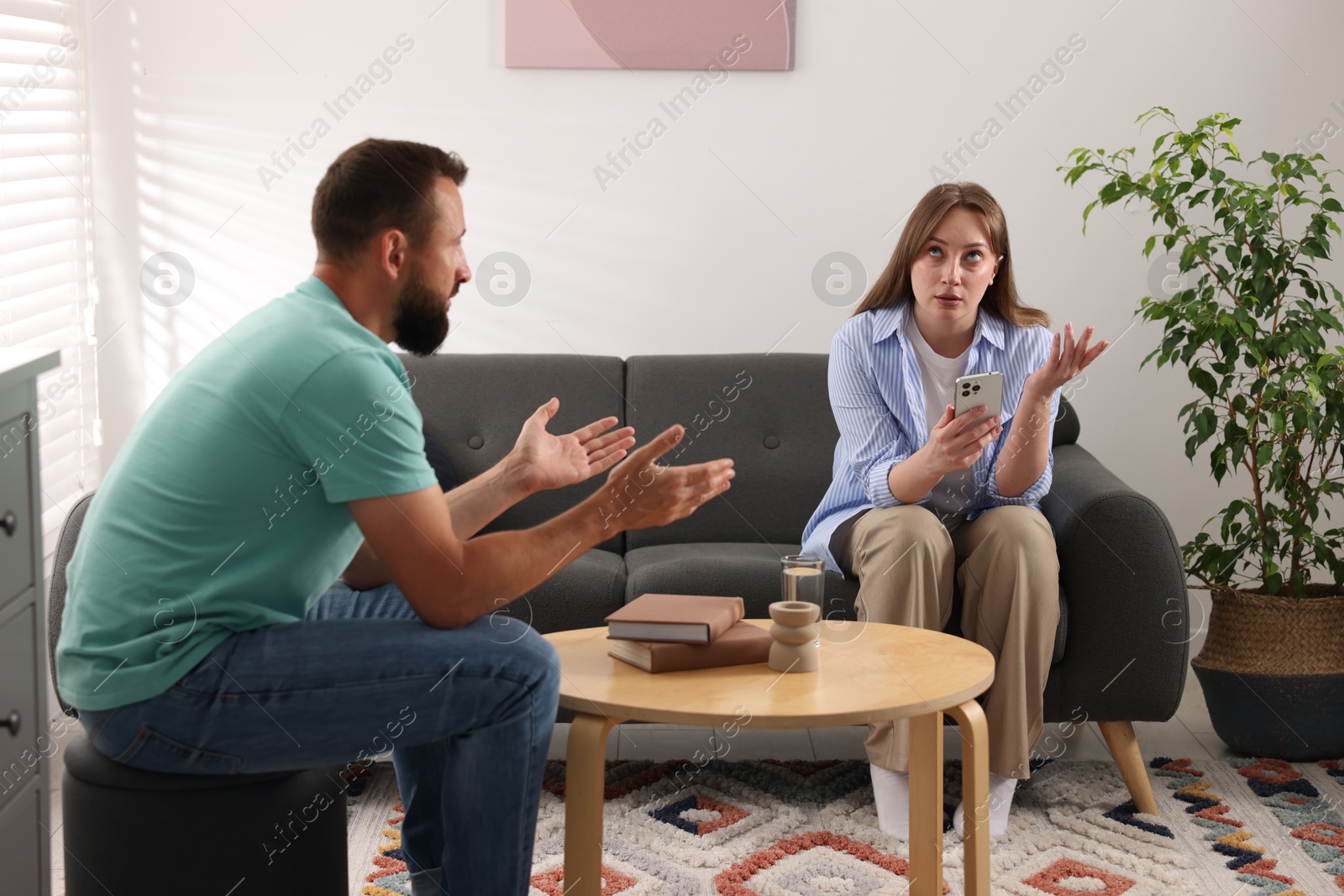 Photo of Betrayal. Emotional couple arguing in living room