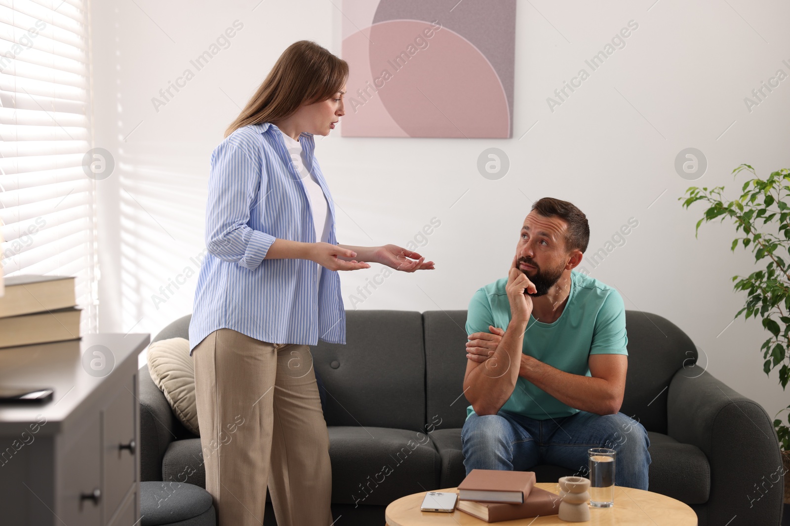 Photo of Betrayal. Emotional woman talking to her husband at home
