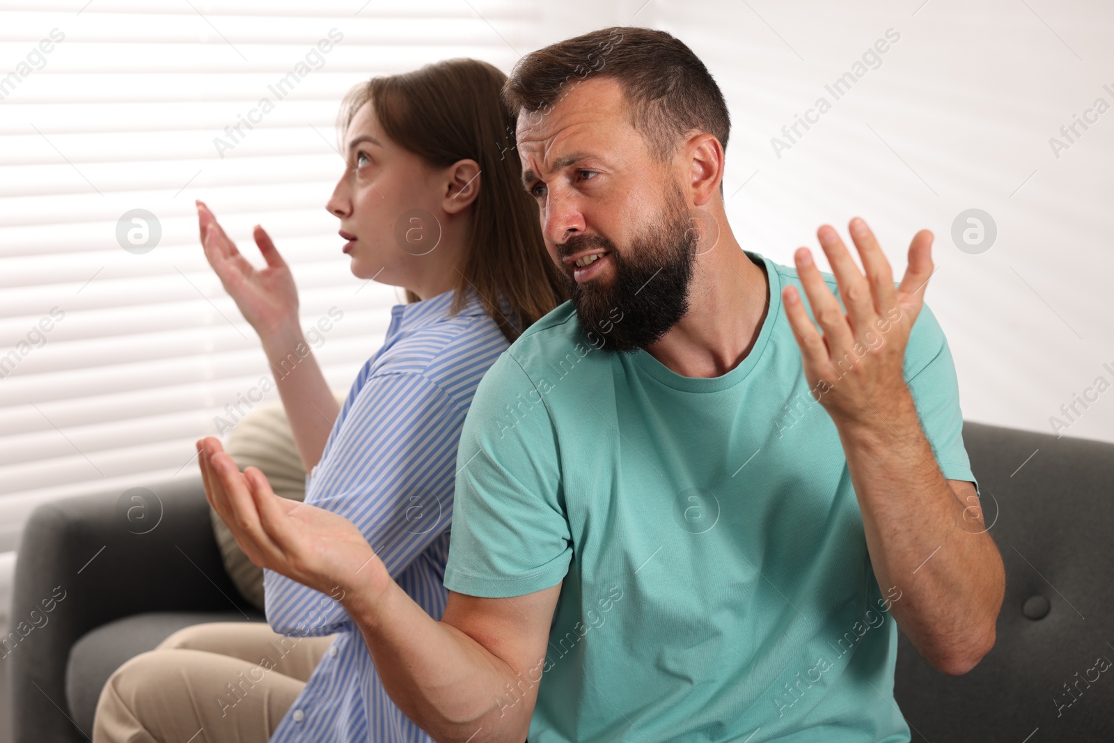 Betrayal. Emotional couple arguing on sofa at home Photo of Betrayal. Emotional couple arguing on sofa at home
