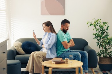 Photo of Betrayal. Offended couple on sofa at home