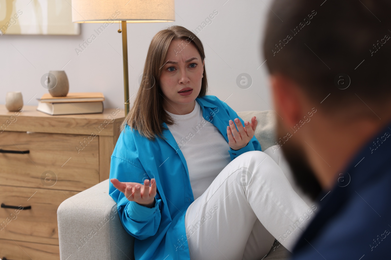 Photo of Betrayal. Woman talking to her husband on sofa at home