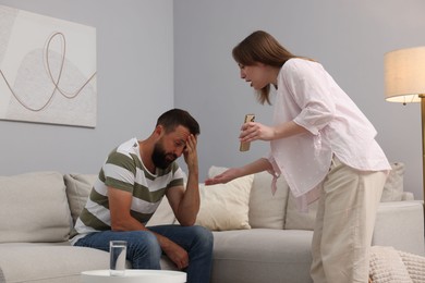 Photo of Betrayal. Wife showing smartphone with proofs to her unfaithful husband at home