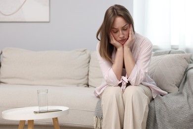 Photo of Betrayal. Lonely frustrated woman on sofa at home
