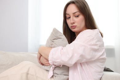 Photo of Betrayal. Lonely frustrated woman hugging pillow on sofa at home