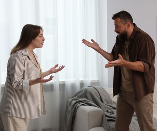 Photo of Betrayal. Emotional couple arguing in living room