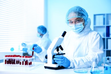 Photo of Medical analysis. Scientist working with microscope in laboratory, selective focus