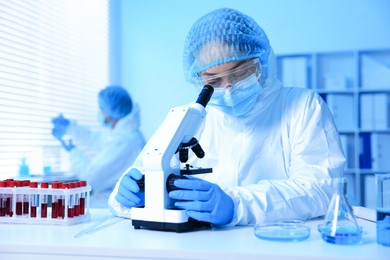 Photo of Medical analysis. Scientist working with microscope in laboratory, selective focus