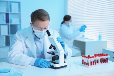 Photo of Medical analysis. Scientist working with microscope in laboratory, selective focus
