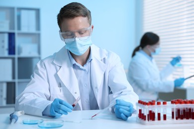 Photo of Medical analysis. Scientist working with blood sample in laboratory, selective focus