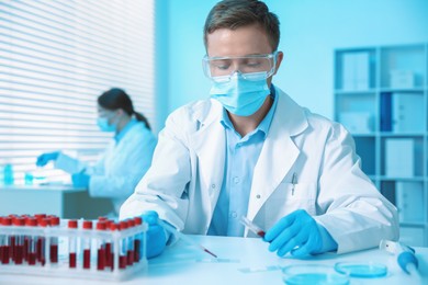 Photo of Medical analysis. Scientist working with blood sample in laboratory, selective focus