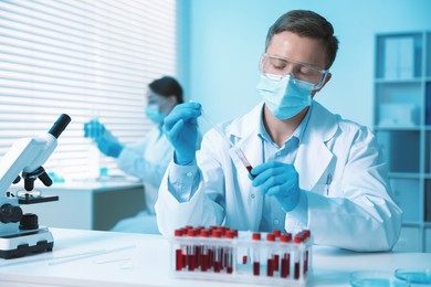 Photo of Medical analysis. Scientist working with blood sample in laboratory, selective focus