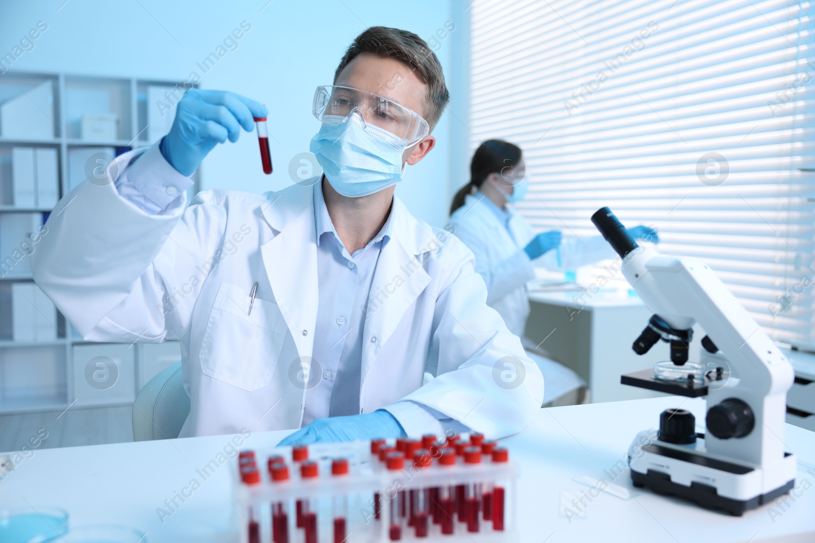 Medical analysis. Scientist working with blood sample in laboratory, selective focus Photo of Medical analysis. Scientist working with blood sample in laboratory, selective focus