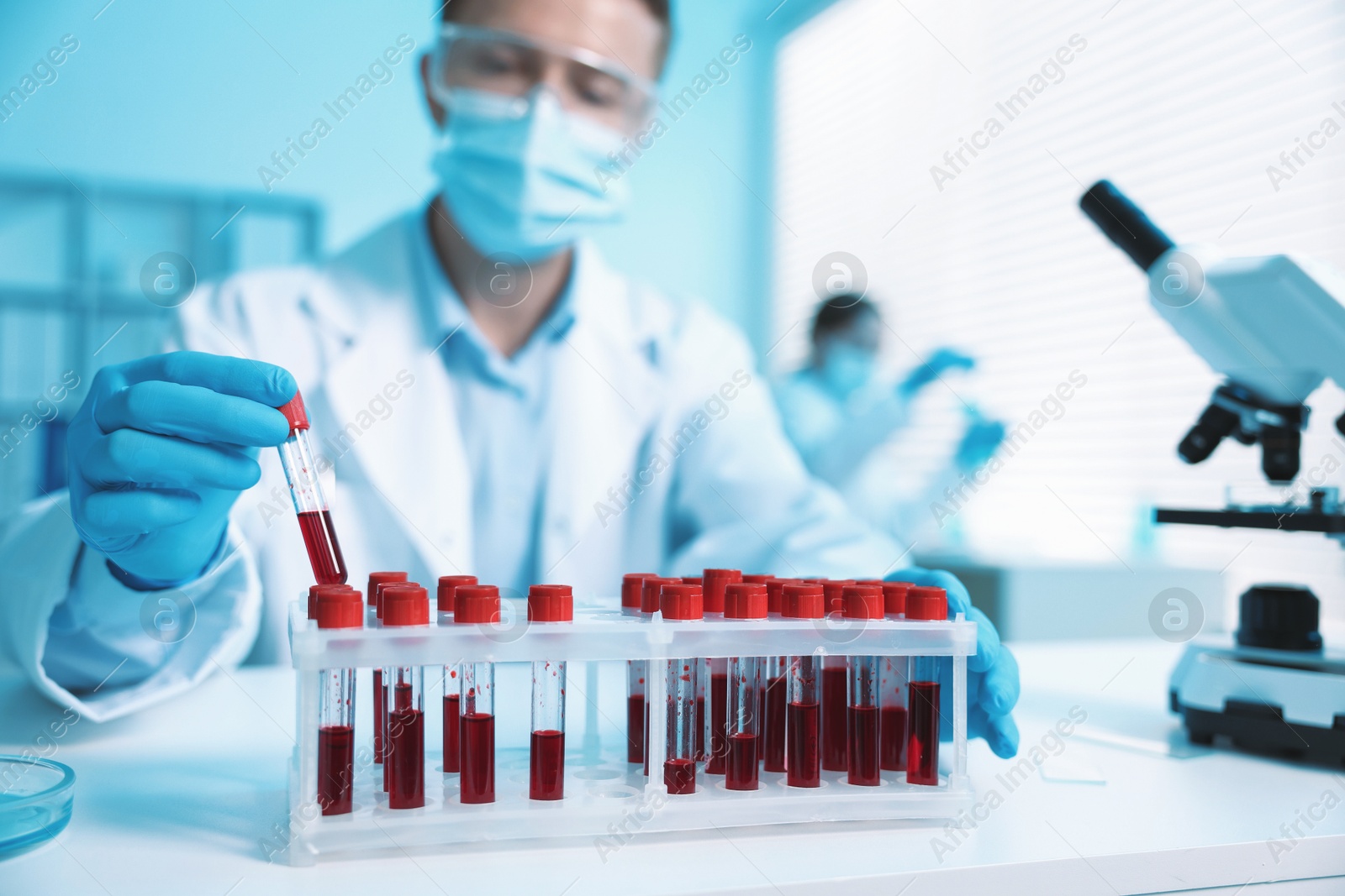 Medical analysis. Scientist working with blood sample in laboratory, selective focus Photo of Medical analysis. Scientist working with blood sample in laboratory, selective focus