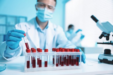 Photo of Medical analysis. Scientist working with blood sample in laboratory, selective focus