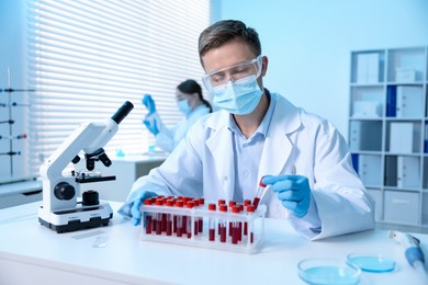 Photo of Medical analysis. Scientist working with blood sample in laboratory, selective focus