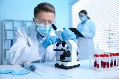 Photo of Medical analysis. Scientist working with microscope in laboratory, selective focus