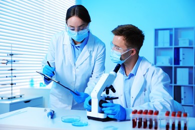 Photo of Medical analysis. Scientists working with microscope in laboratory