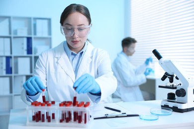 Photo of Medical analysis. Scientist working with blood samples in laboratory, selective focus