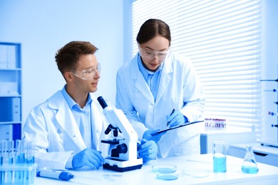 Photo of Medical analysis. Scientists working with microscope in laboratory