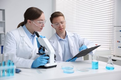 Photo of Medical analysis. Scientists working with microscope in laboratory