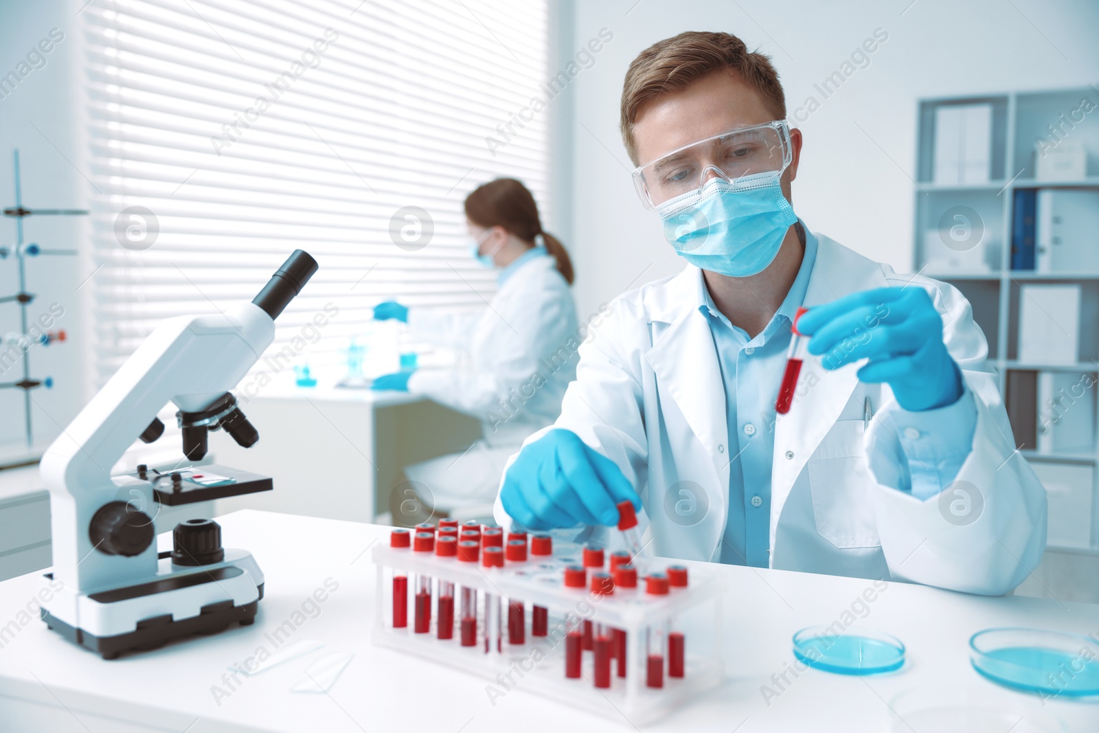 Medical analysis. Scientist working with blood sample in laboratory, selective focus Photo of Medical analysis. Scientist working with blood sample in laboratory, selective focus