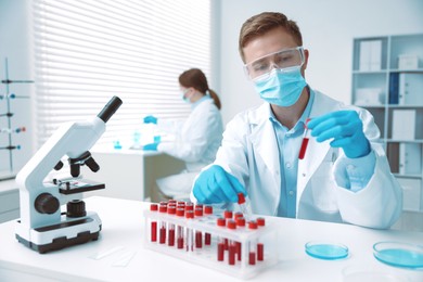 Photo of Medical analysis. Scientist working with blood sample in laboratory, selective focus