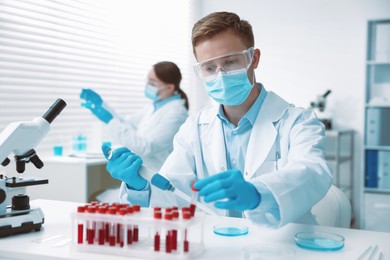 Photo of Medical analysis. Scientist working with blood sample in laboratory, selective focus