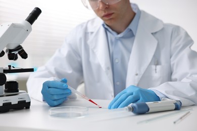 Photo of Medical analysis. Scientist working with blood sample in laboratory, closeup