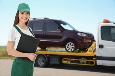Image of Car service worker with clipboard near auto and tow truck outdoors