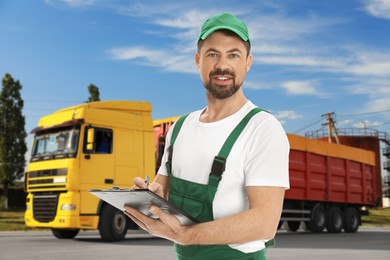 Image of Car service worker with clipboard and truck outdoors
