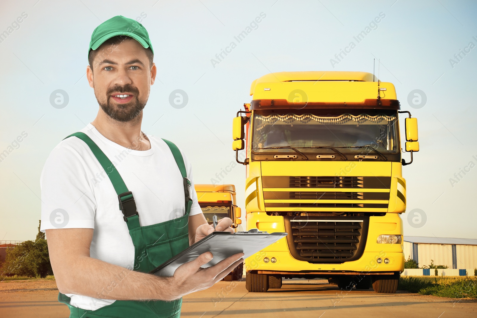 Car service worker with clipboard and trucks outdoors Image of Car service worker with clipboard and trucks outdoors
