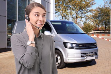 Image of Car service worker with headset against vehicle outdoors. Client support