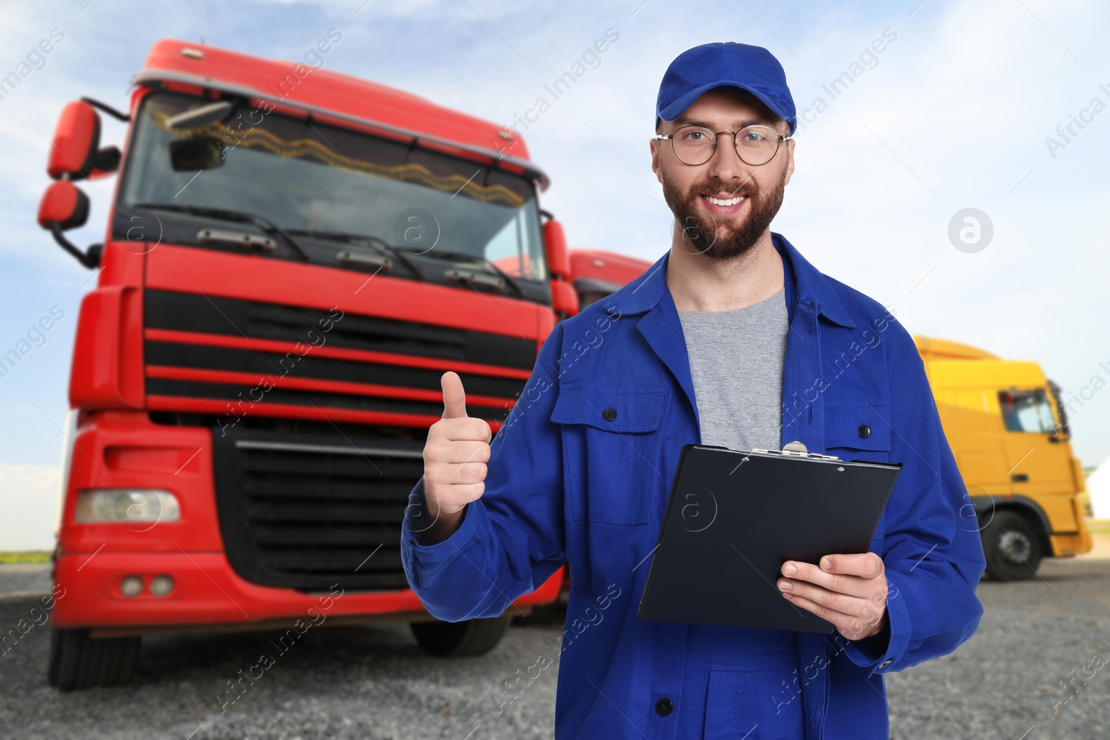 Image of Car service worker with clipboard and truck outdoors
