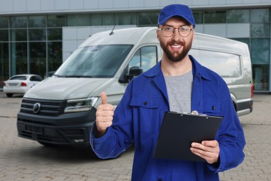 Image of Car service worker with clipboard and vehicle outdoors